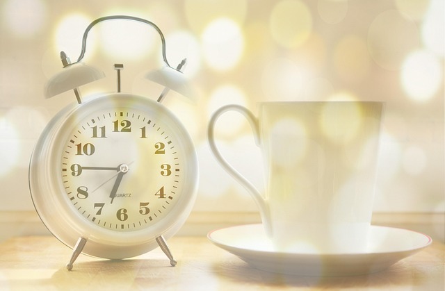 alarm clock beside a neatly folded towel and running shoes on a clean floor